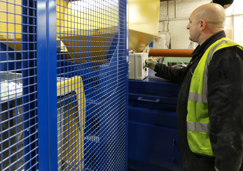 A man in a hi-vis jacket using waste equipment