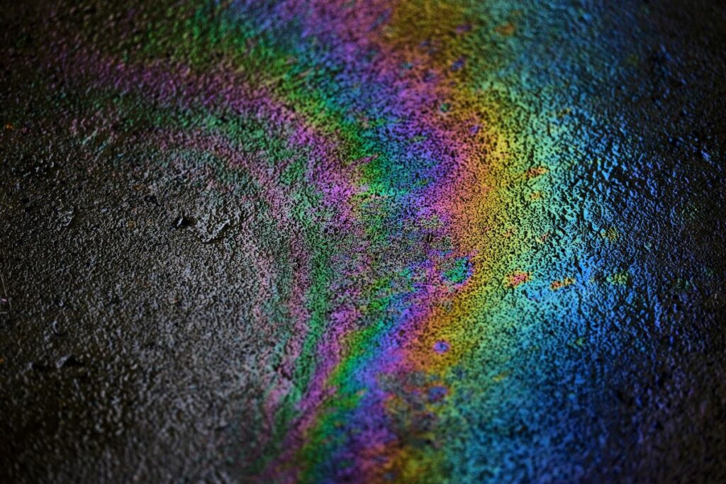 Oil waste on the pavement which creates a rainbow pattern.
