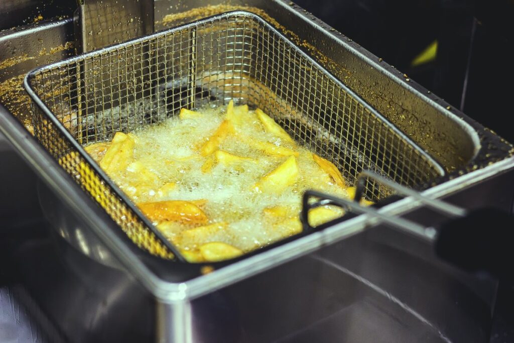 A deep fat fryer frying chips. This produces oil waste