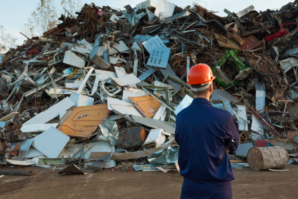 A man stood in front of a landfill site